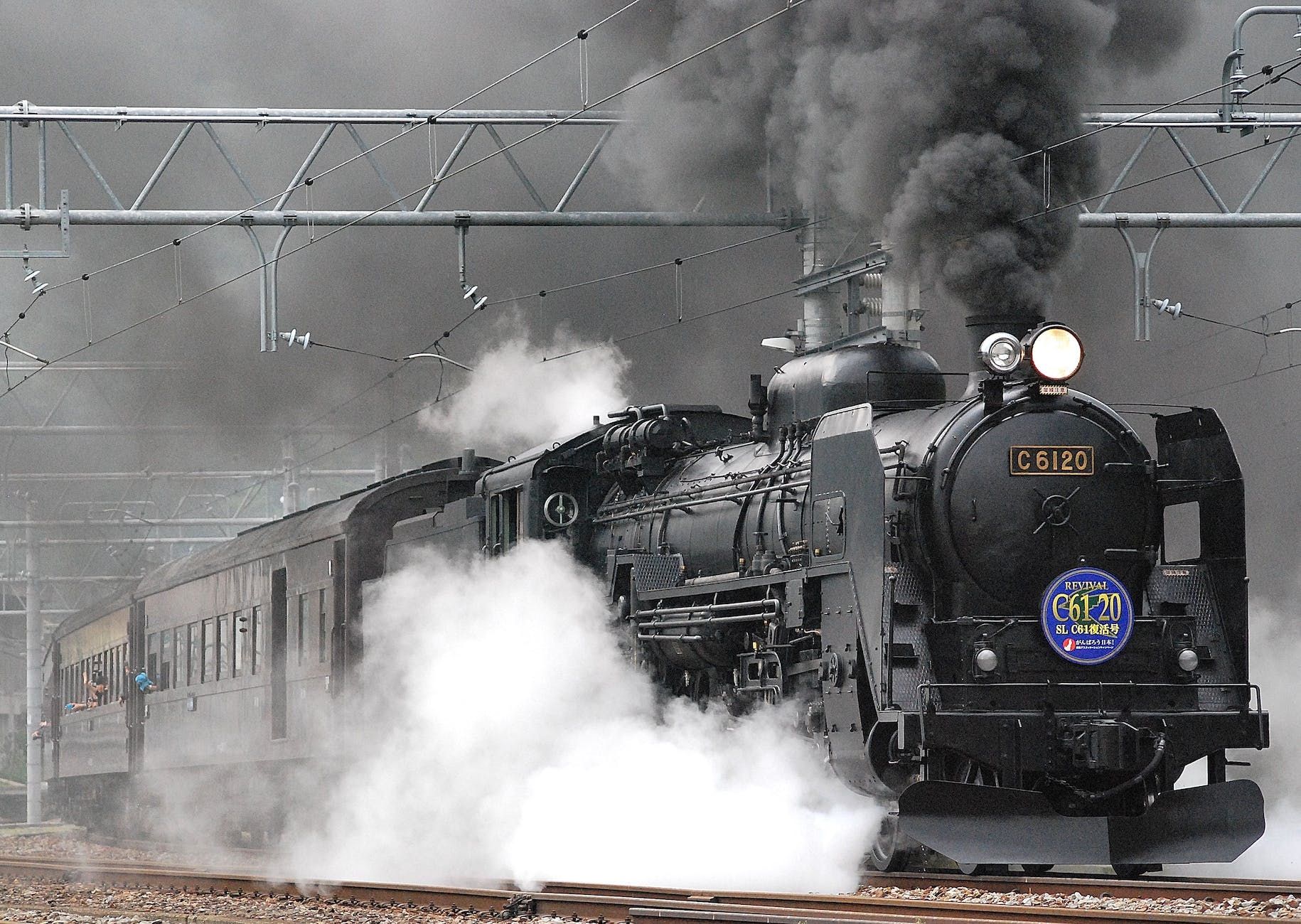 black train on rail and showing smoke
